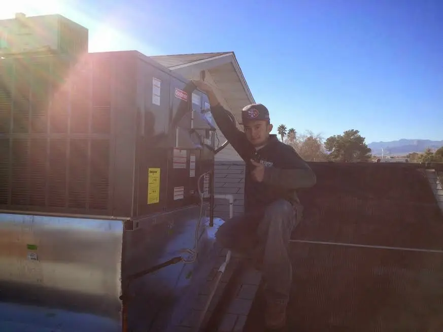 HVAC technician performing HVAC Inspection on a rooftop unit in Bowie